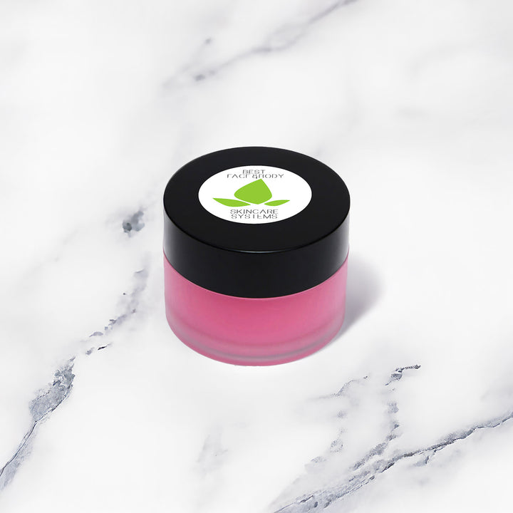 A small cylindrical beauty product shown at an angle on a white marble surface.