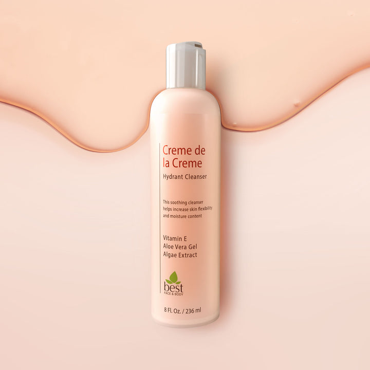 A bottle of Creme de la Creme hydrating cleanser against a light pink background.