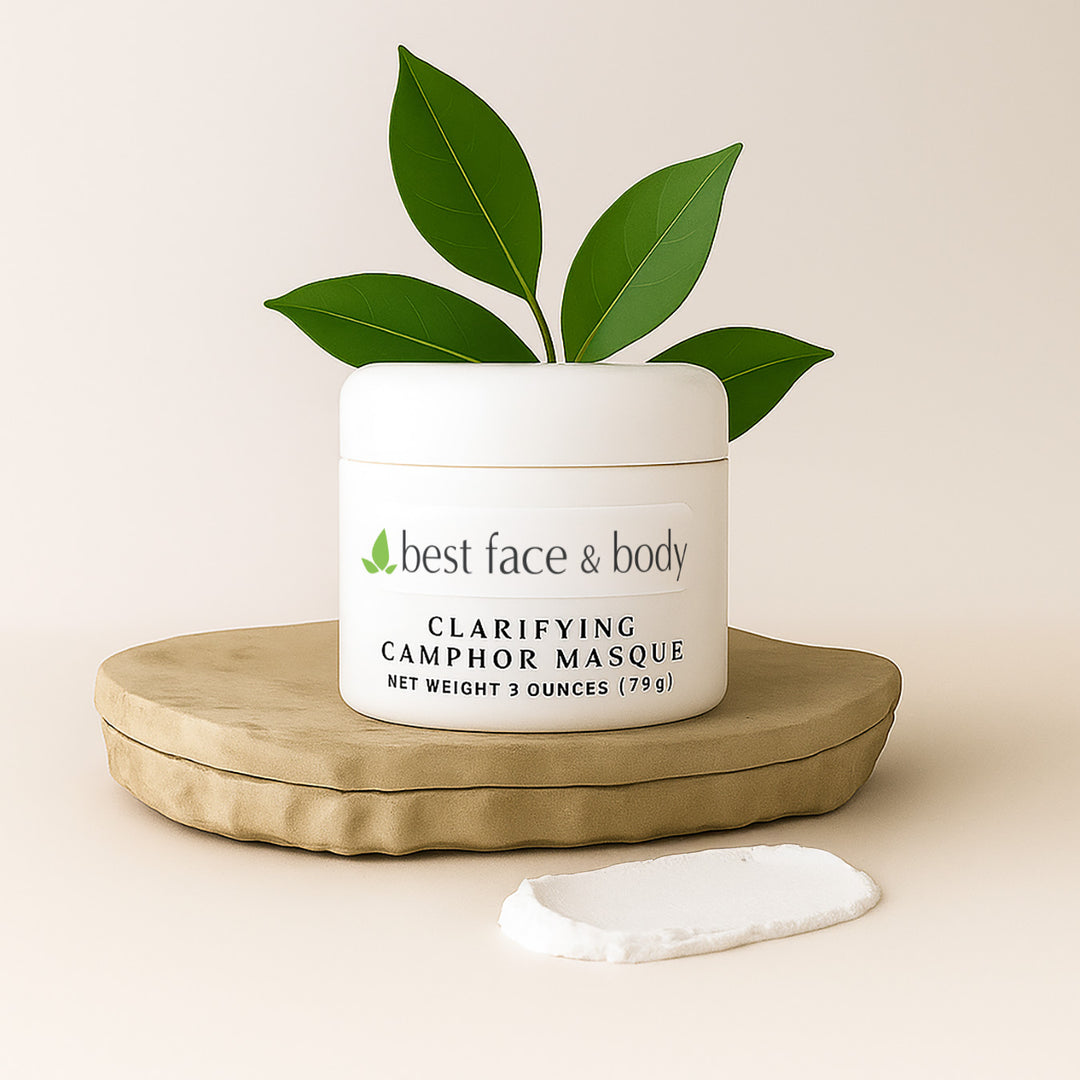 White jar of 'best face & body' clarifying camphor masque with green leaves on a beige background