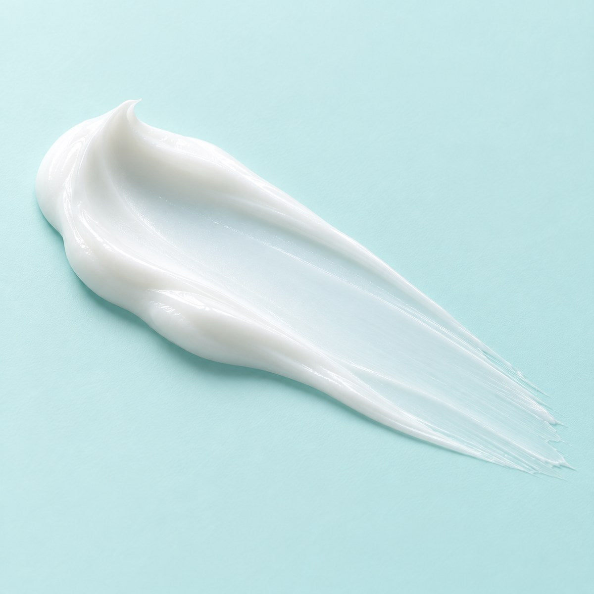 Swipe of light white oil-free moisturizer on a pale aqua background