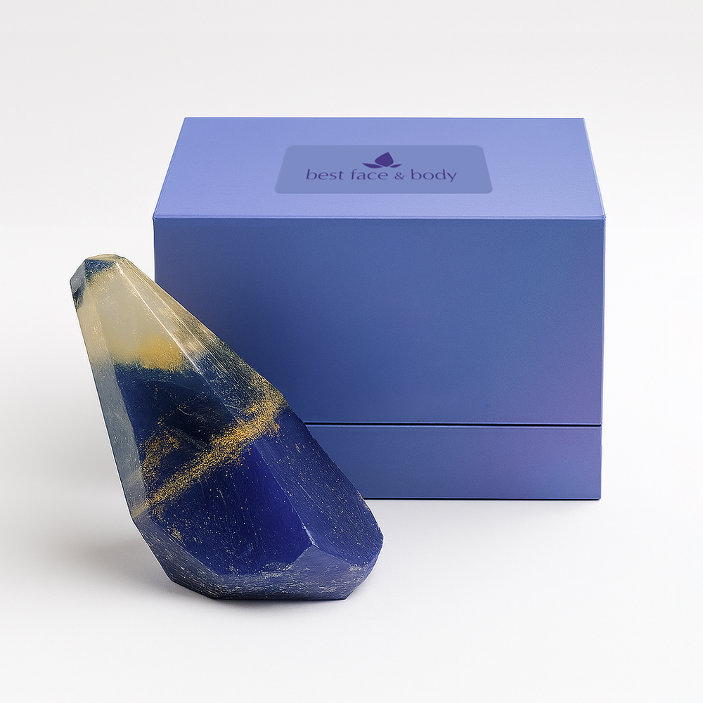 Blue crystal soap with gold accents in front of a blue box labeled 'best face & body' on a white background