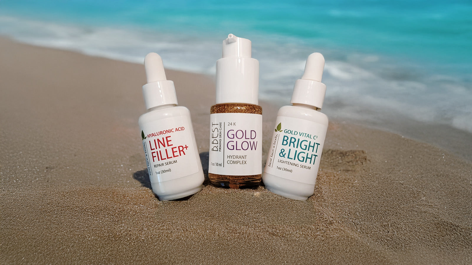 Three skincare bottles on a sandy beach with ocean in the background