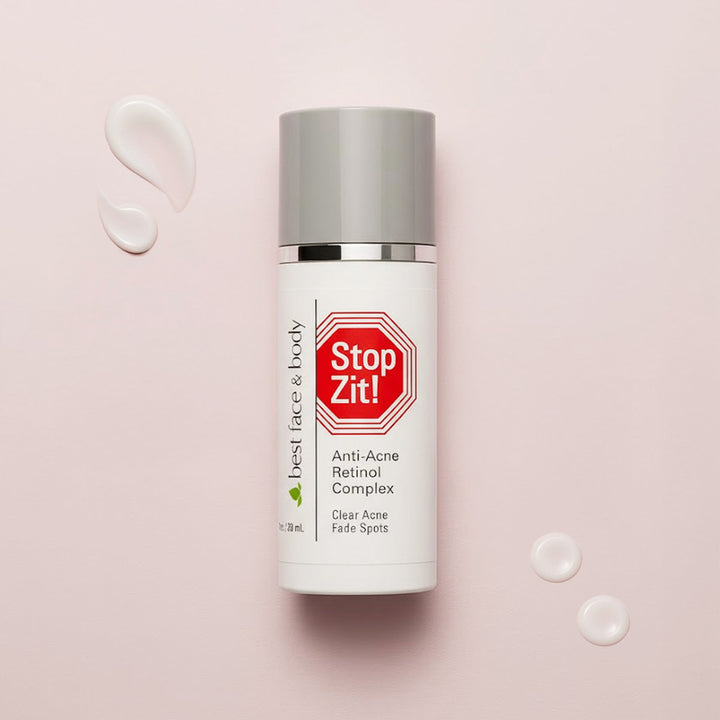 Skincare bottle labeled 'Stop Zit!' on a pink background