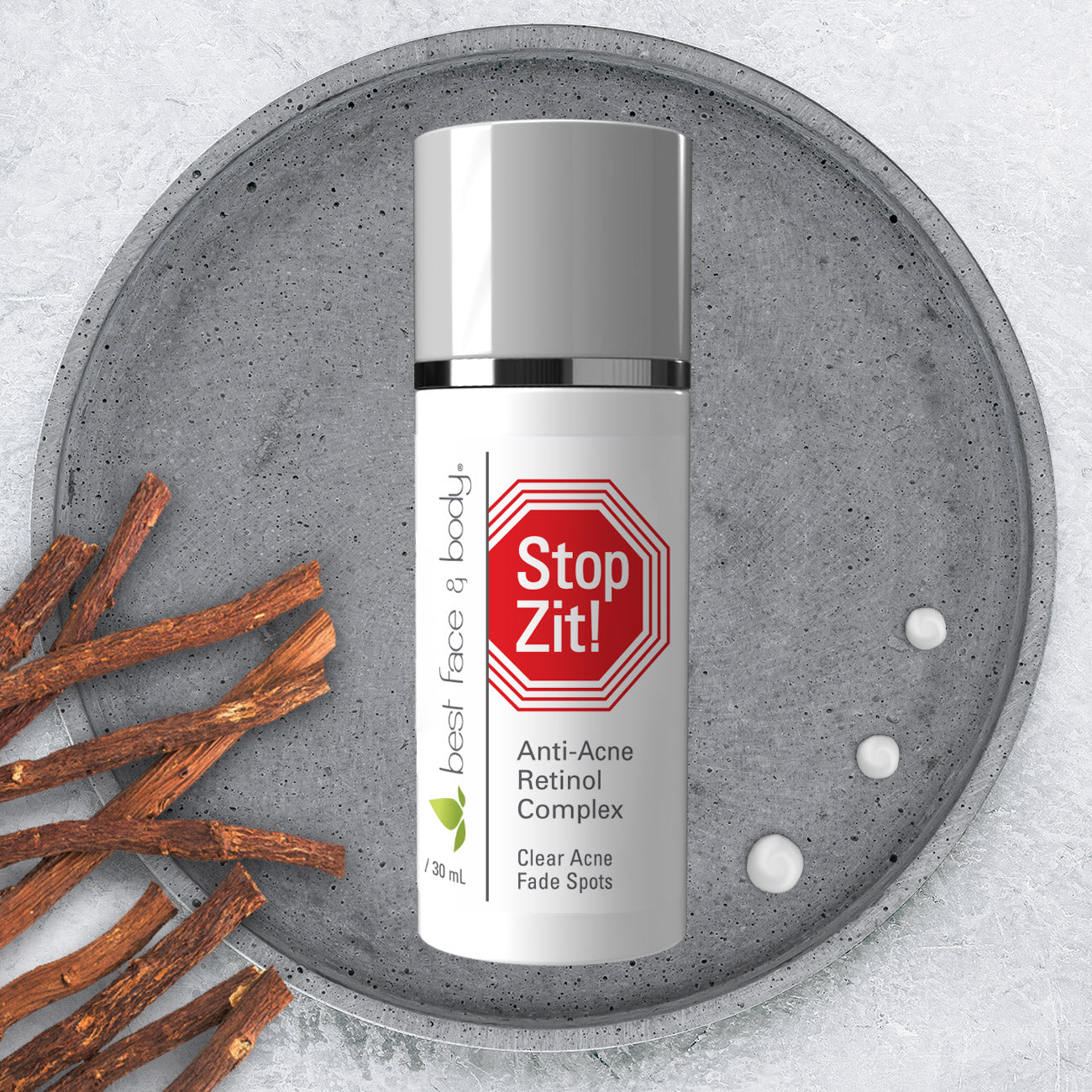 Stop Zit Anti-Acne Retinol Complex pictured on shallow stone dish with willow bark and serum drops on side.