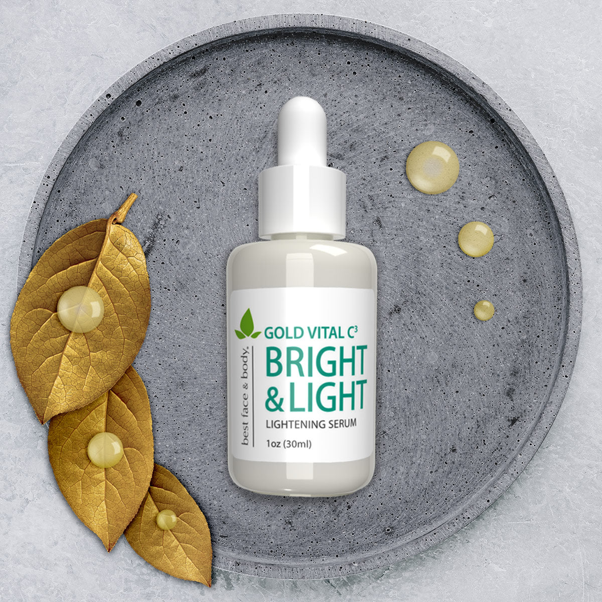 Gold Vital C3 Bright & Light Lightening Serum. 1 oz glass bottle with white dropper top, pictured on grey stone dish with decorative gold leaves and serum drops on the side.